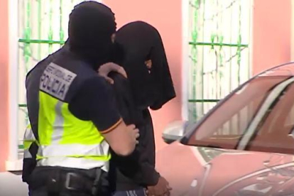 Trasladan al yihadista detenido en Madrid tras el registro en su vivienda. El presunto islamista ha salido de la casa con la cabeza cubierta-ATLAS