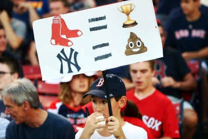 Un joven sostiene una pancarta con dibujos de 'emojis' en el partido de béisbol entre los New York Yankees y los Boston Red Sox de este domingo.-AFP