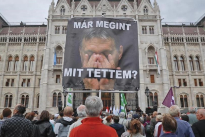 Un hombre sostiene un póster con la imagen de Orbán donde se lee: '¿Qué he hecho otra vez?', en un acto de protesta de partidos opositores al presidente húngaro, en Budapest, este domingo.-AP / VADIM GHIRDA