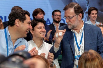Mariano Rajoy habla con el líder del PP andaluz, Juanma Moreno, y el presidente de Nuevas Generaciones, Diego Gago, en la convención de Sevilla.-EFE / JULIO MUÑOZ