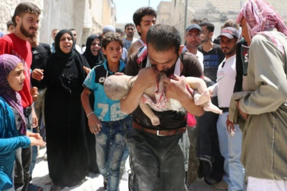Un hombre sostiene el cuerpo sin vida de su hijo en brazos tras uno de los bombardeos en el barrio rebelde de Al-Marjah, en el norte de Alepo, este domingo.-AFP / AMEER ALHALBI