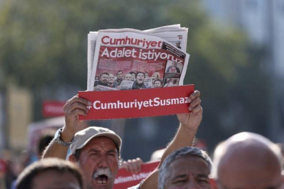 Un hombre muestra una copia del periódico Cumhuriyet durante la concentracion de esta mañana delante del Palacio de Justicia de Estambul (Turquía)-ERDEM SAHIN