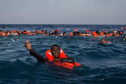 Refugiados e inmigrantes nadan y piden ayuda cerca de Lampedusa, el pasado mayo.-GETTY IMAGES / CHRIS MCGRATH