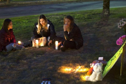 Unas jóvenes encienden velas en memoria de las víctimas del tiroteo en Burlington.-AFP / GETTY / KAREN DUCEY