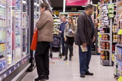 Un grupo de personas comprando en un supermercado.-FERRAN NADEU