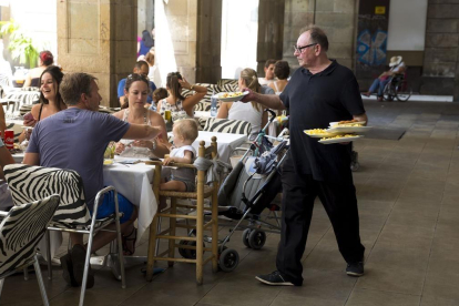 Un camarero sirve a un grupo de clientes en una terraza de Barcelona-JOSEP GARCIA