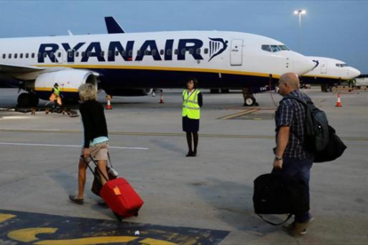 Pasajeros de Ryanair trasladando el equipaje a la aeronave.-/ REUTERS / KEVIN COOMBS