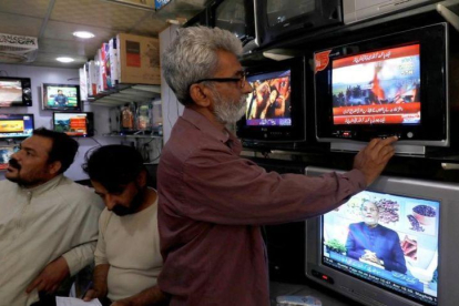 Un ciudadano pakistaní se informa tras el derribo de dos cazas indios.-AKHTAR SOOMRO (REUTERS)