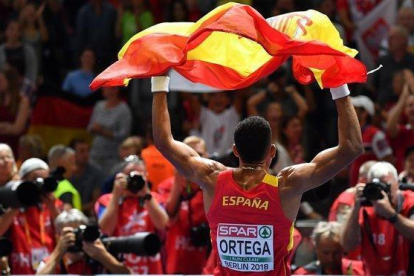 Orlando Ortega, con la bandera española tras quedar tercero en el Europeo de Berlín, el año pasado.-AFP / ANDREJ ISAKOVIC