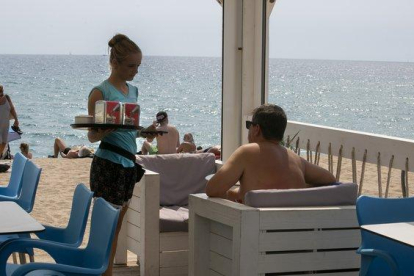Una camarera en un chiringuito de playa trabajando durante el verano.-MAITE CRUZ