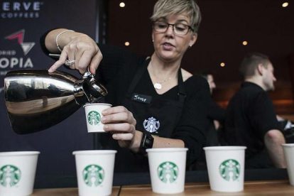 Una camarera de Starbucks sirve cafés durante un encuentro de accionistas de la compañía, el pasado marzo en Seattle.-REUTERS / DAVID RYDER