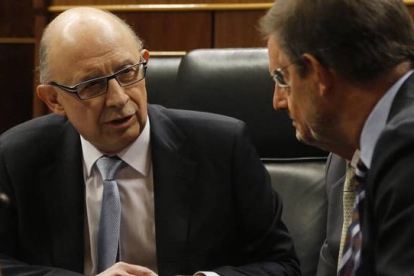 El ministro de Hacienda, Cristóbal Montoro, conversa con el presidente del Gobierno, Mariano Rajoy, este martes durante el debate sobre los Presupuestos en el Congreso.-Foto: AGUSTÍN CATALÁN