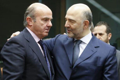 Luis de Guindos y el comisario europeo de Asuntos Económicos, Pierre Moscovici, ayer, en Bruselas.-EFE/OLIVIER HOSLET