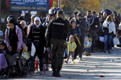 Cientos de refugiados esperan para registrarse en el campamento de Preshevo, en Serbia, este domingo-REUTERS