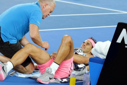 El osteópata atiende a Nadal antes de que el tenista tuviera que retirarse en el Open de Australia.-/ MARK CRISTINO