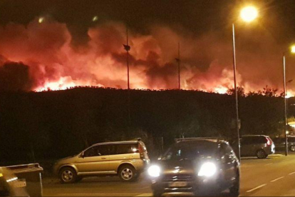 Una columna de llamas, al fondo, esta noche, en el gran incendio de Bormes-les-Mimosas.-EL PERIÓDICO (@JOHANROUQUET / @INFOEMERG)