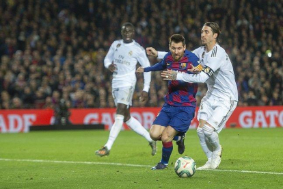 Messi y Sergio Ramos pelean por un balón.-JORDI COTRINA