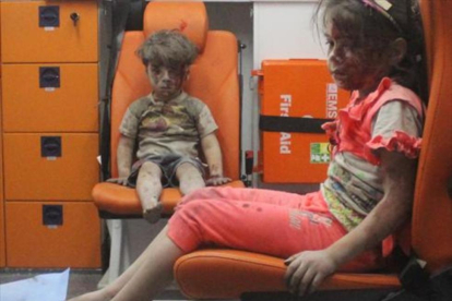 El pequeño Omran, de 5 años, junto a su hermana, tras ser rescatados de un edificio bombardeado el miércoles en Alepo.-REUTERS