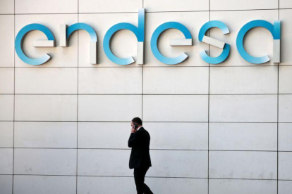 Un hombre camina bajo el logo de Endesa en la sede de la empresa en Madrid-ANDREA COMAS (REUTERS)