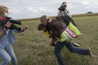 Momento en el que Petra Laszlo le hizo la zancadilla a Osama Abdul Mohsen, que corría con su hijo pequeño a cuestas, cerca de la frontera húngara.-REUTERS / MARKO-DJURICA