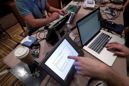 Unos hackers intentan acceder a los datos de una máquina de votación durante una convención en Las Vegas.-STEVE MARCUS (REUTERS)