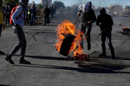 Manifestantes palestinos queman un neumático en protesta por la decisión de EEUU, en Ramalá, este martes 26 de diciembre-AFP / ABBAS MOMANI