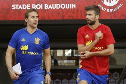 Julen Lopetegui y Gerard Piqué saltan al césped del estadio Rey Baldunio antes del entrenamiento de este miércoles.-SERGIO BARRENECHEA / EFE