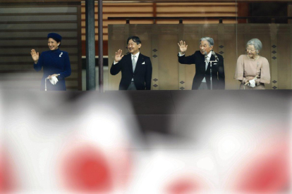 Emperor Akihito  waves to national flag-waving well-wishers with Empress Michiko,  Crown Prince Naruhito and Crown Princess Masako after delivering his speech marking his 85th birthday  his last birthday on the throne  at the Imperial Palace in Tokyo-KIMIMASA MAYAMA / EPA