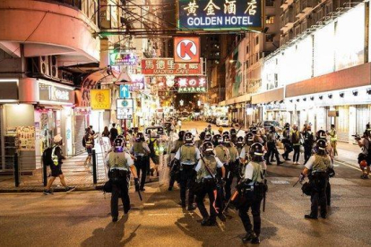 Un grupo de policías antidisturbios toma posición en una calle de Hong Kong.-