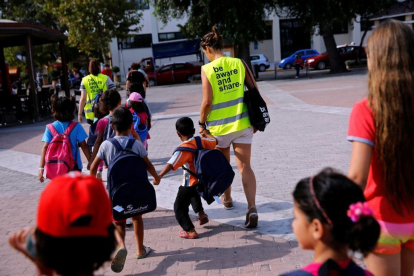 Unos voluntarios acompañan a la escuela a niños refugiados en la isla griega de Chios.-ALKIS KONSTANTINIDIS / REUTERS