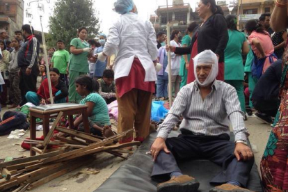 Algunos heridos reciben tratamiento en las puertas del Hospital de Katmandú.-AP