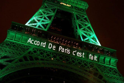 La torre Eiffel de París, iluminada de color verde para celebrar la firma de los acuerdos contra el cambio climático por parte de la comunidad internacional.-JACKY NAEGELEN (REUTERS)