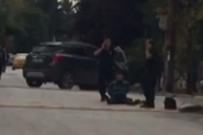 Uno de los asaltantes, en el suelo, ante la embajada de Israel.-