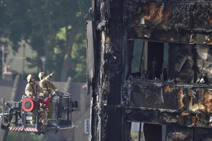 Los bomberos todavía trabajan en la torre Grenfell.-REUTERS / HANNAH MCKAY