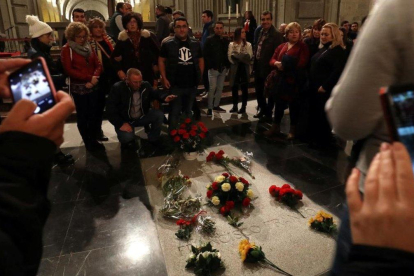 Varios ciudadanos posan ante la tumba de Franco en el Valle de los Caídos, este sábado.-SUSANA VERA (REUTERS)
