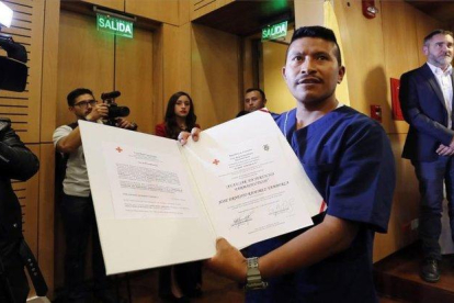 Un excombatiente de las FARC muestra su título en servicios sanitarios otorgado por la Cruz Roja de Colombia.-EFE