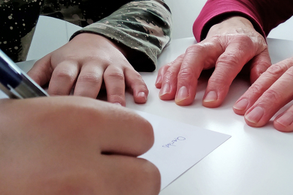Un joven soriano inicia una carta junto a una septuagenaria. A.C.