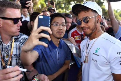 Lewis Hamilton se hace fotos con aficionados en Melbourne.-AFP / WILLIAM WEST