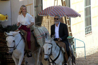 George Clooney y Brie Larson, a lomos de sendos burros, por el centro de Navalcarnero (Madrid).-AYUNTAMIENTO DE NAVALCARNERO