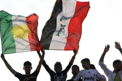 Aficionados de futbol sostienen banderas kurdas e iraquís en un partido de su selección. En una foto de archivo.-AFP / SAFIN HAMED (AFP)