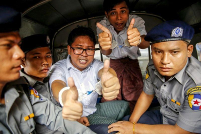 Los reporteros birmanos de la agencia Reuters Wa Lone  i  y Kyaw Soe Oo posan antes de abandonar el tribunal del distrito de Insein luego que la Justicia birmana los condenó a siete anos de prision acusados de vulnerar la Ley de Secretos Oficiales.-LYNN BO BO (EFE)