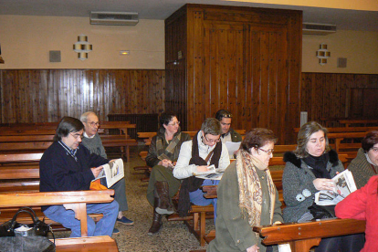 Un grupo de vecinos sentados en los bancos de la parroquia de la Sor María. / EVA SÁNCHEZ-