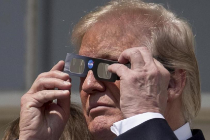 Trump se prepara para ver el eclipse de sol, en la Casa Blanca.-AP / ANDREW HAMIK