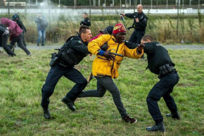 Policías franceses intentan parar a los inmigrantes que buscan colarse al Eurotúnel en Calais este miércoles.-Foto:   AFP / PHILIPPE HUGUEN
