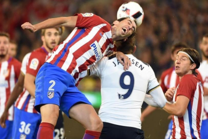 Godín, defensa uruguayo del Atlético, despeja un balón ante Janssen.-AFP / SAEED KHAN