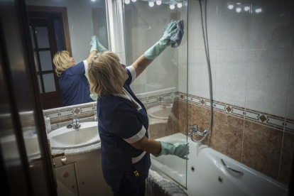 Una mujer de limpieza en un hogar realizando sus labores profesionales.  /-CARLOS MONTANYES (EL PERIÓDICO)