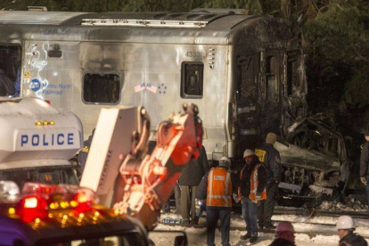 Los servicios de emergencias, ante la locomotora del tren y el vehículo, totalmente calcinado, en Valhalla (Nueva York).-Foto: AFP / MICHAEL GRAAE