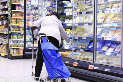 Una mujer en la sección de productos congelados de un supermercado.-FERRAN NADEU