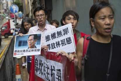 Varios seguidores del alcalde de la localidad meriodional de Wukan, Lin Zuluan, sostienen pancartas y protestan de camino a la oficina china Liaison en Hong Kong.-JEROME FAVRE / EFE
