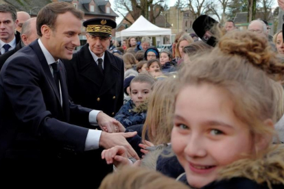 Macron saluda a los residentes a su llegada a un centro de migrantes en Croisilles, en el norte de Francia, el 16 de enero.-EFE / MICHEL SPINGLER